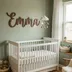 Scalloped walnut-stained nursery name sign with a child's name and small hearts laser-engraved into the face., view 2