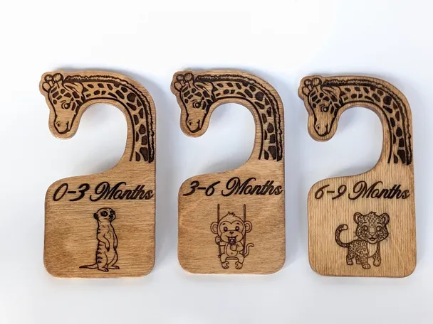 Three Baltic birch closet dividers photographed together, showing the engraved giraffe necks and the size label on each