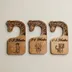 Set of three giraffe-neck closet dividers side by side on a warm neutral surface, each engraved with a size range and its own safari animal