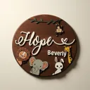 Round dark walnut nursery sign on a warm neutral wall, the name in raised white script with a leafy vine across the top and hand-painted safari animals below: a hanging monkey, a lion, an elephant, a bunny, and a giraffe