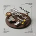 Labeled diagram of the round Baltic birch name sign calling out the birch backer, hand-painted figures and laser-cut layers