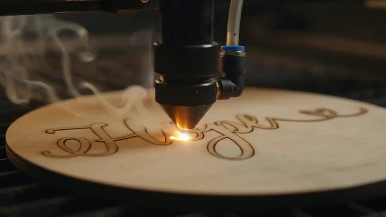 Our laser cutter engraving a name into a wood sign in the Denver studio